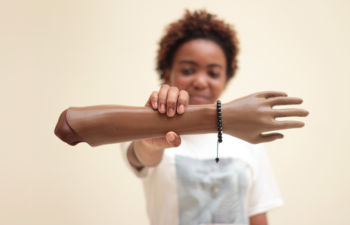 Ebe holding her Limb Forge 3D-printed arm.