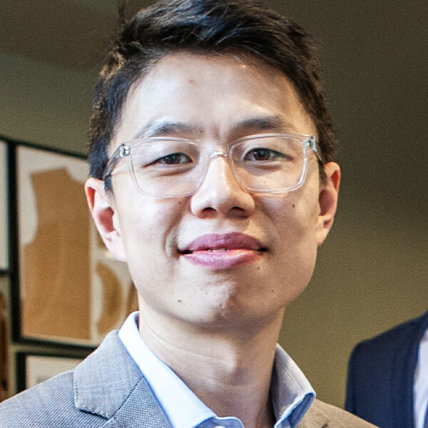 Headshot of Fan Bi wearing eyeglasses and a collared shirt.