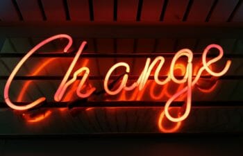 A neon sign that reads "Change" against a black background