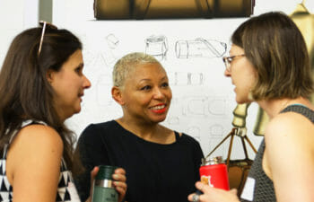 Three Women in Conversation and Smiling