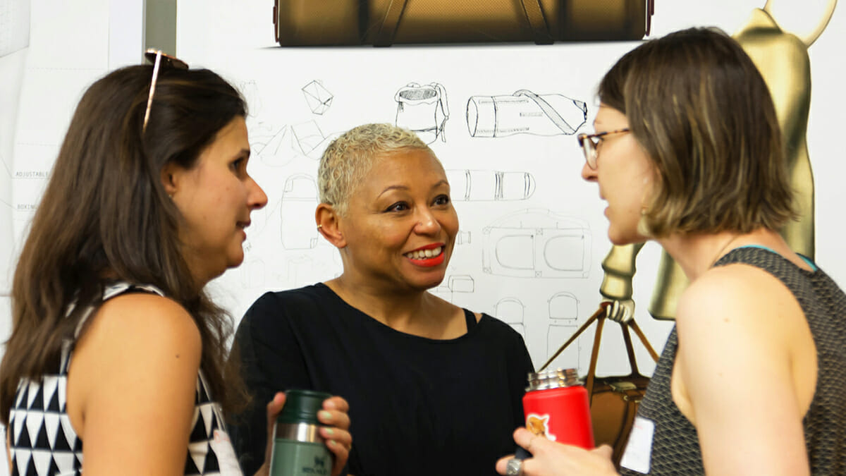 Three Women in Conversation and Smiling