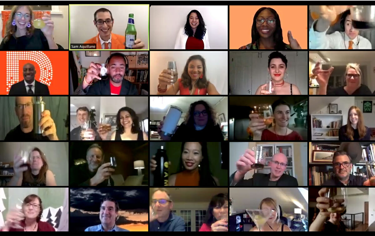 People holding up glasses on a video call