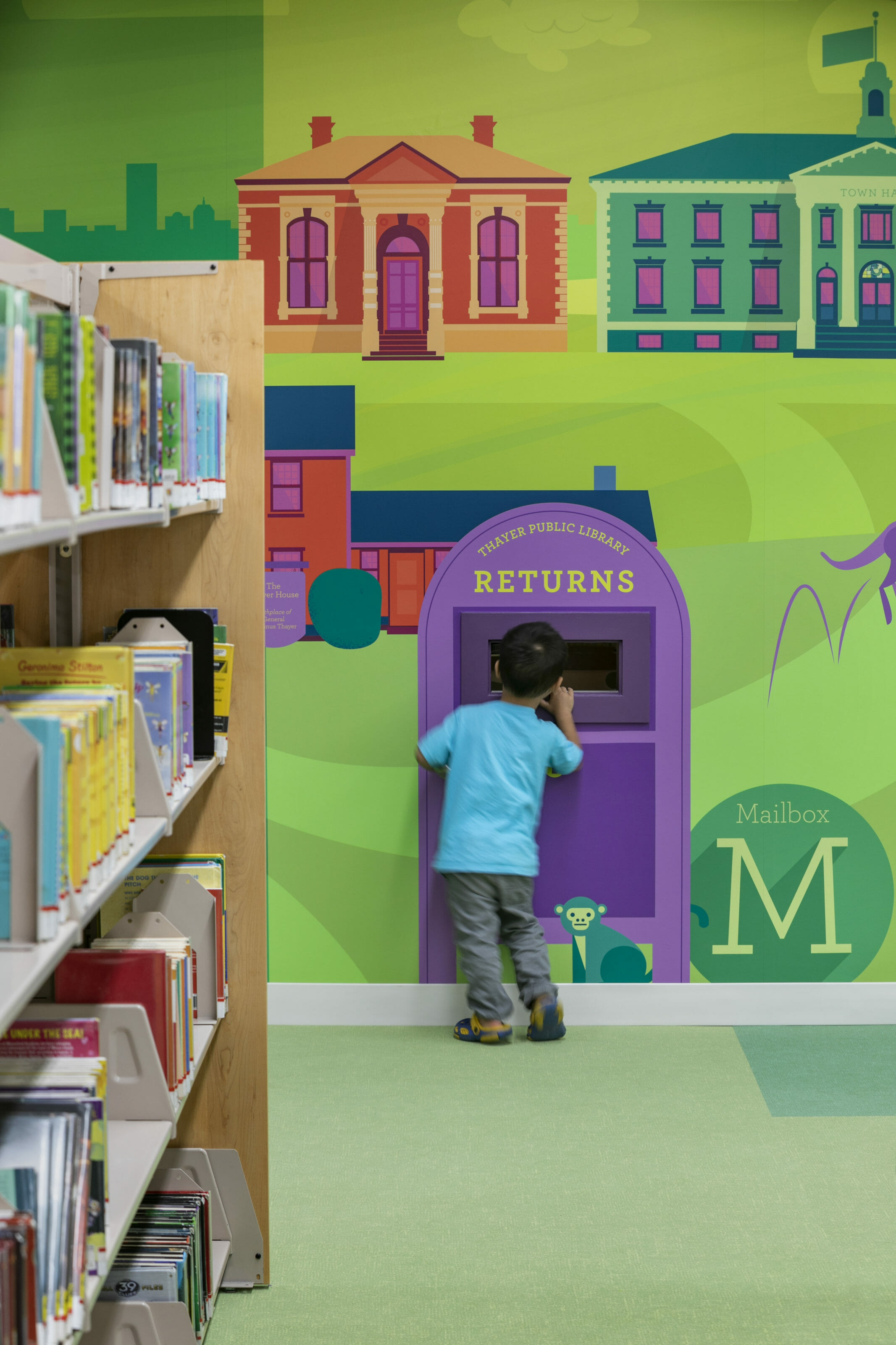 Child interacting with colorful graphics on a wall