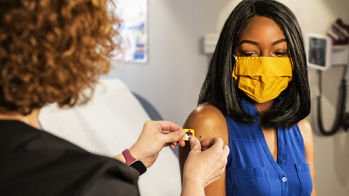 Person with mask getting vaccinated