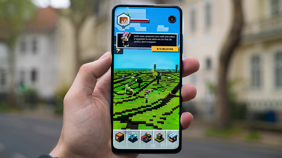 Person holding an iPhone with Minecraft on the screen