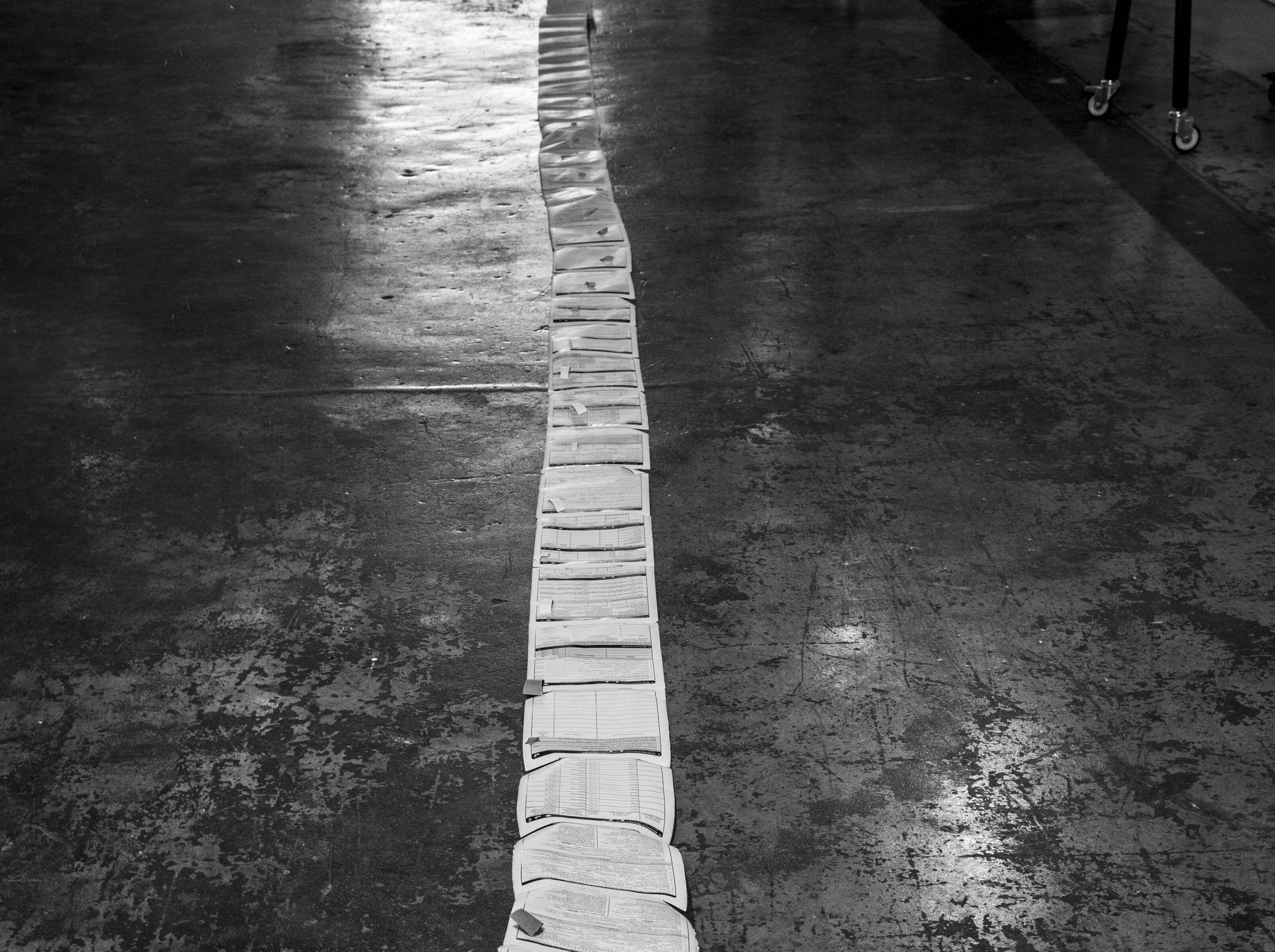 Long white scroll of paper against dark floor