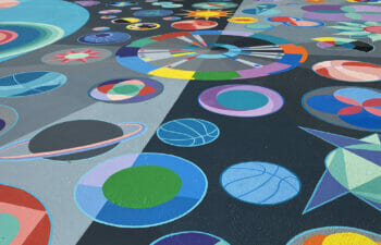 Basketball court painted with various abstract shapes by artist Maria Moteni.