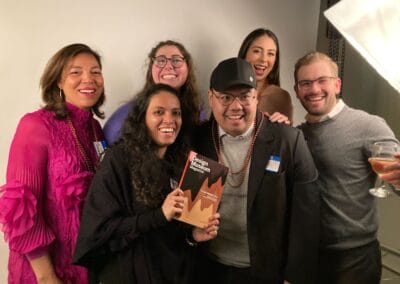 LLM Design team posing for a group photo with a copy of The We Design Issue.