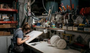 Tilemaker working at a workbench in a studio.