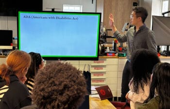 Cohort of High School Design Challenge participants listening to a presentation on the ADA (Americans with Disabilities Act).