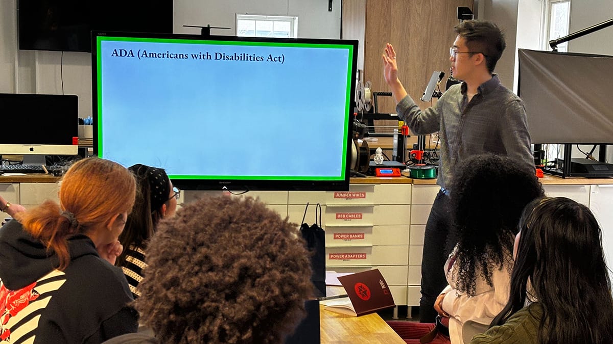 Cohort of High School Design Challenge participants listening to a presentation on the ADA (Americans with Disabilities Act). 