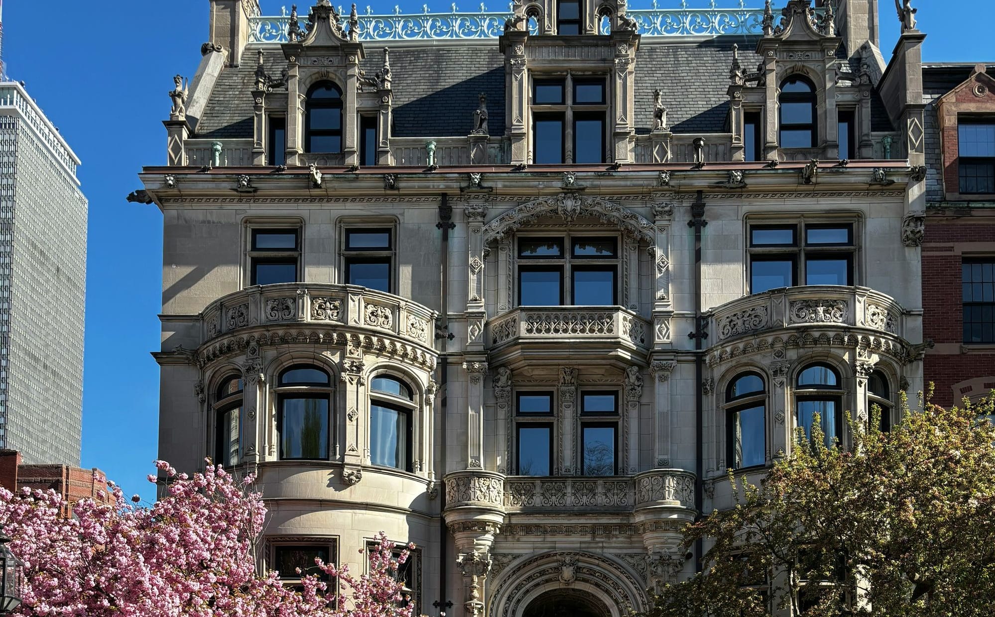 Historic stone multi-story stone building framed by trees in blossom