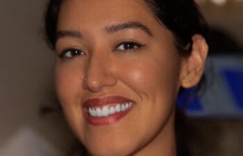 Woman with brown hair and brown eyes smiling