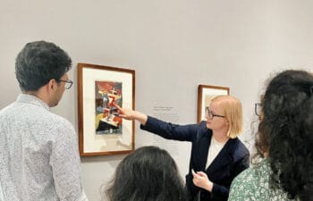 Catherine showing participants a painting in a gallery setting