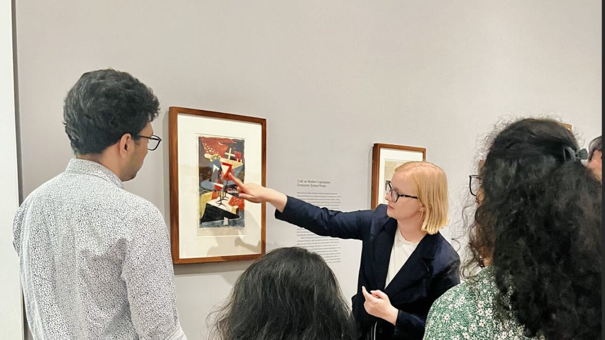 Catherine showing participants a painting in a gallery setting