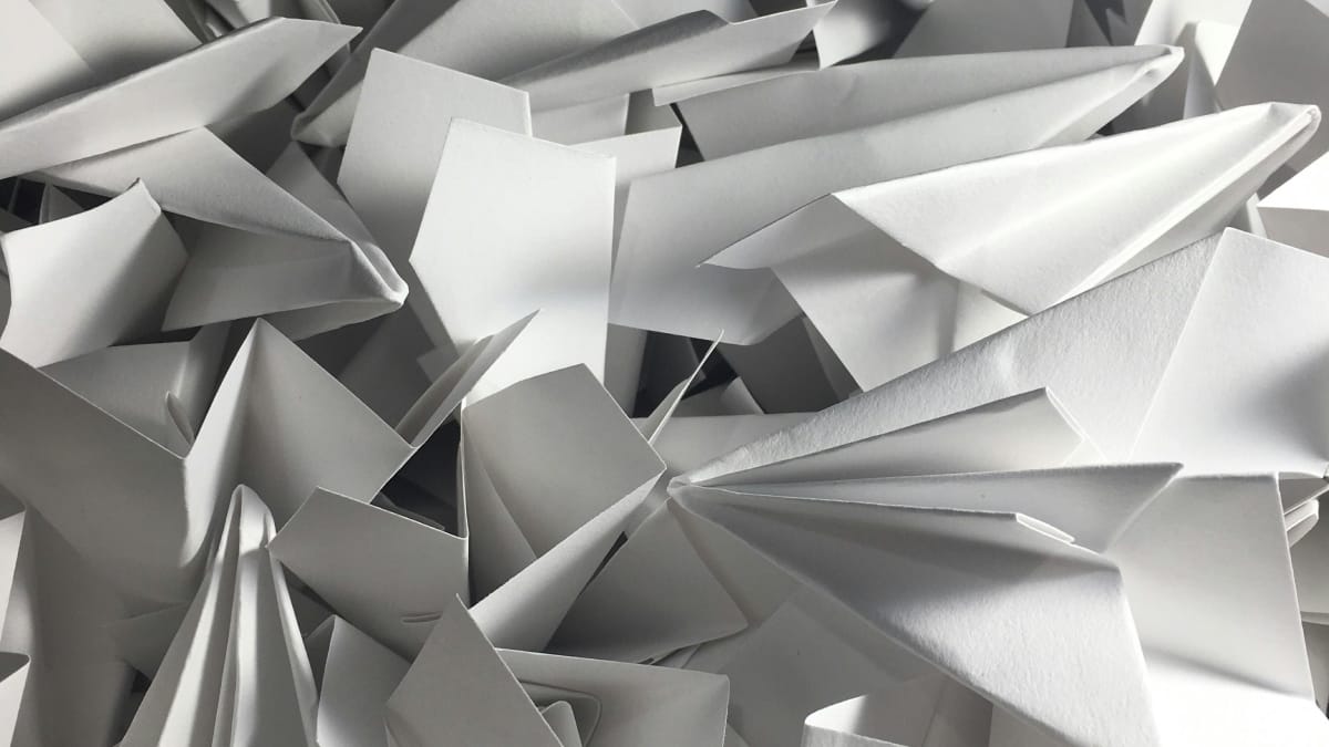 Countless paper airplanes in a pile